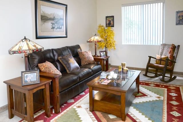 A cozy living room with a leather sofa, wooden coffee table, and decorative items.