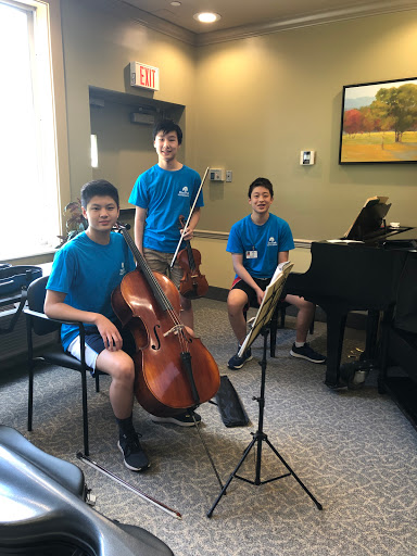 Young musicians preparing for a performance with a cello and piano.