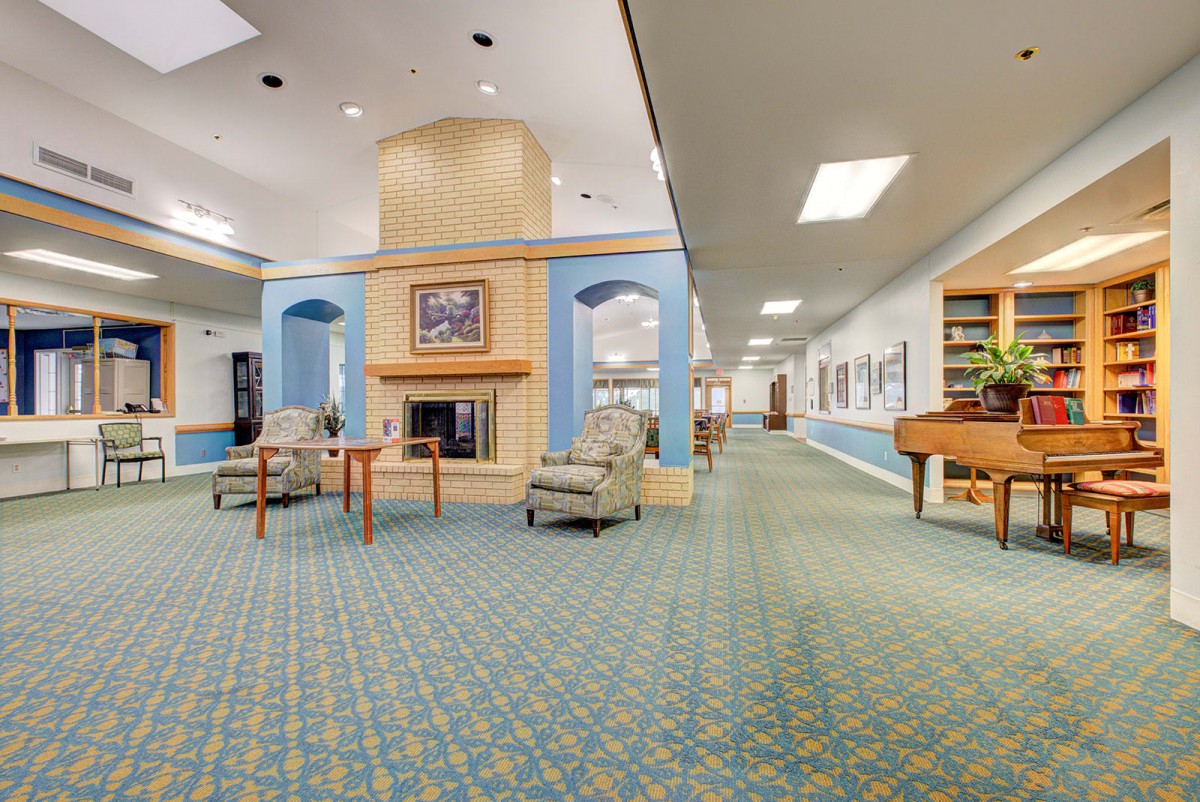 A spacious lobby with comfortable seating and a central fireplace.