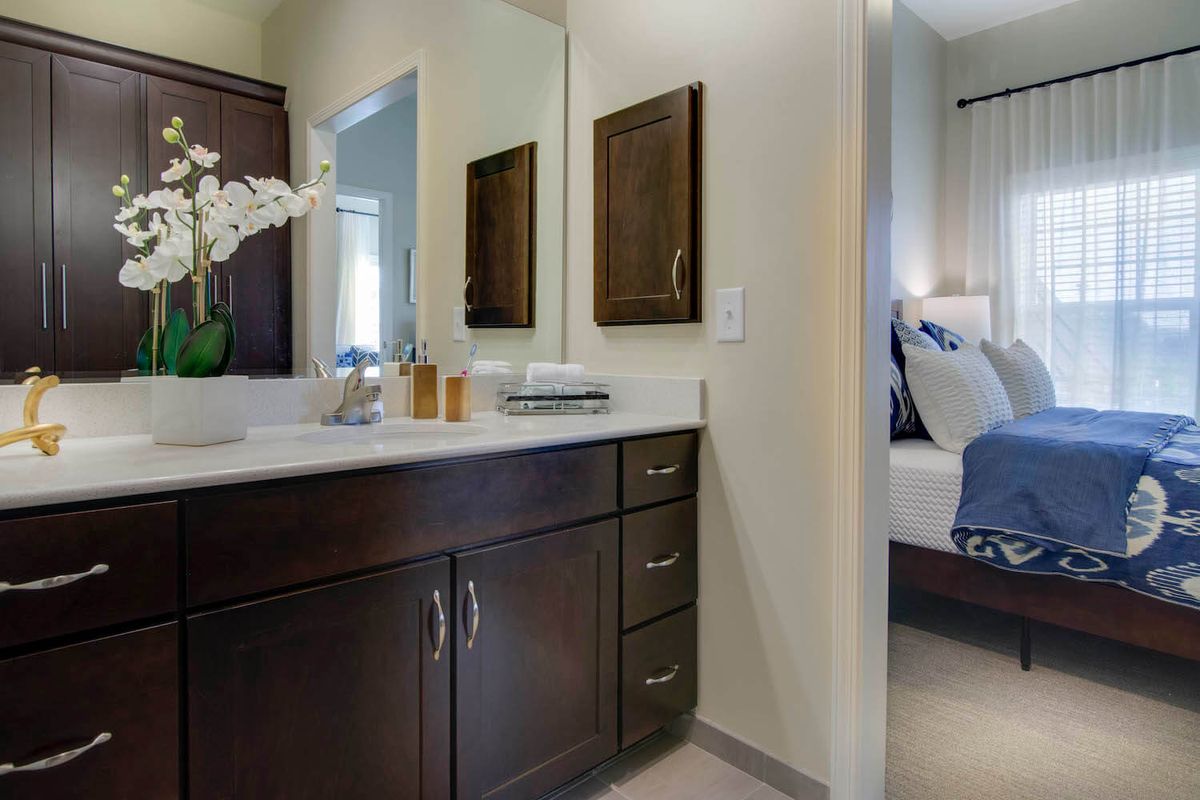 A modern bathroom with dark wood cabinets and elegant decor.