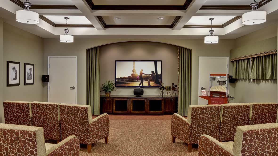 A cozy home theater setup with comfortable seating, a large flat-screen TV, and elegant interior design.