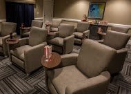Cozy theater room with plush armchairs and popcorn.
