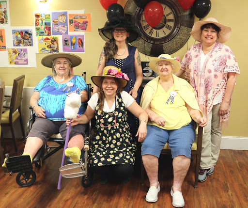 A joyful gathering of women wearing vibrant hats, celebrating together.