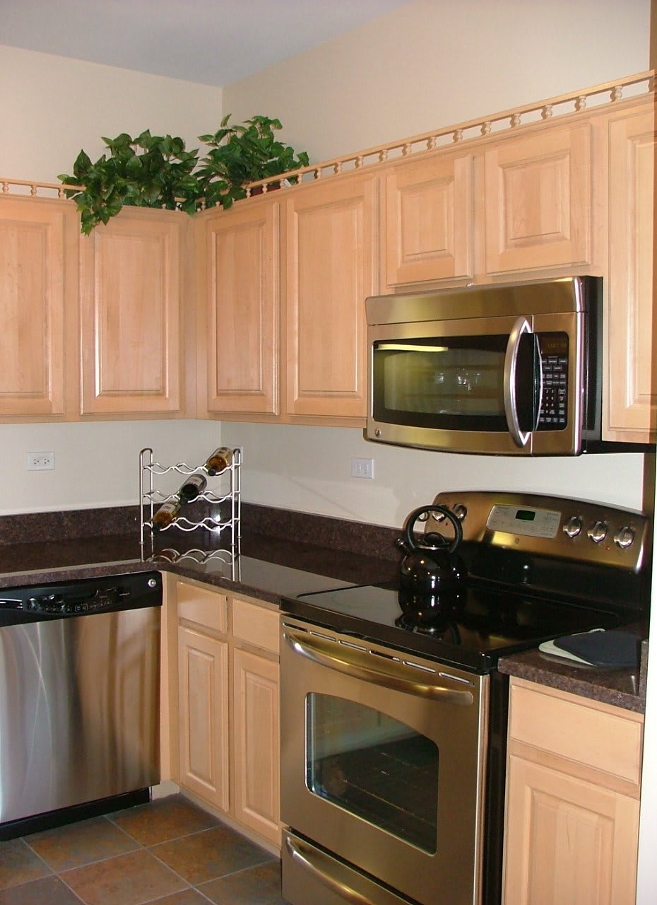 A modern kitchen with stainless steel appliances and wooden cabinets.