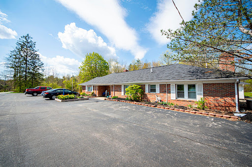 A well-maintained residential building with a landscaped front and ample parking space.