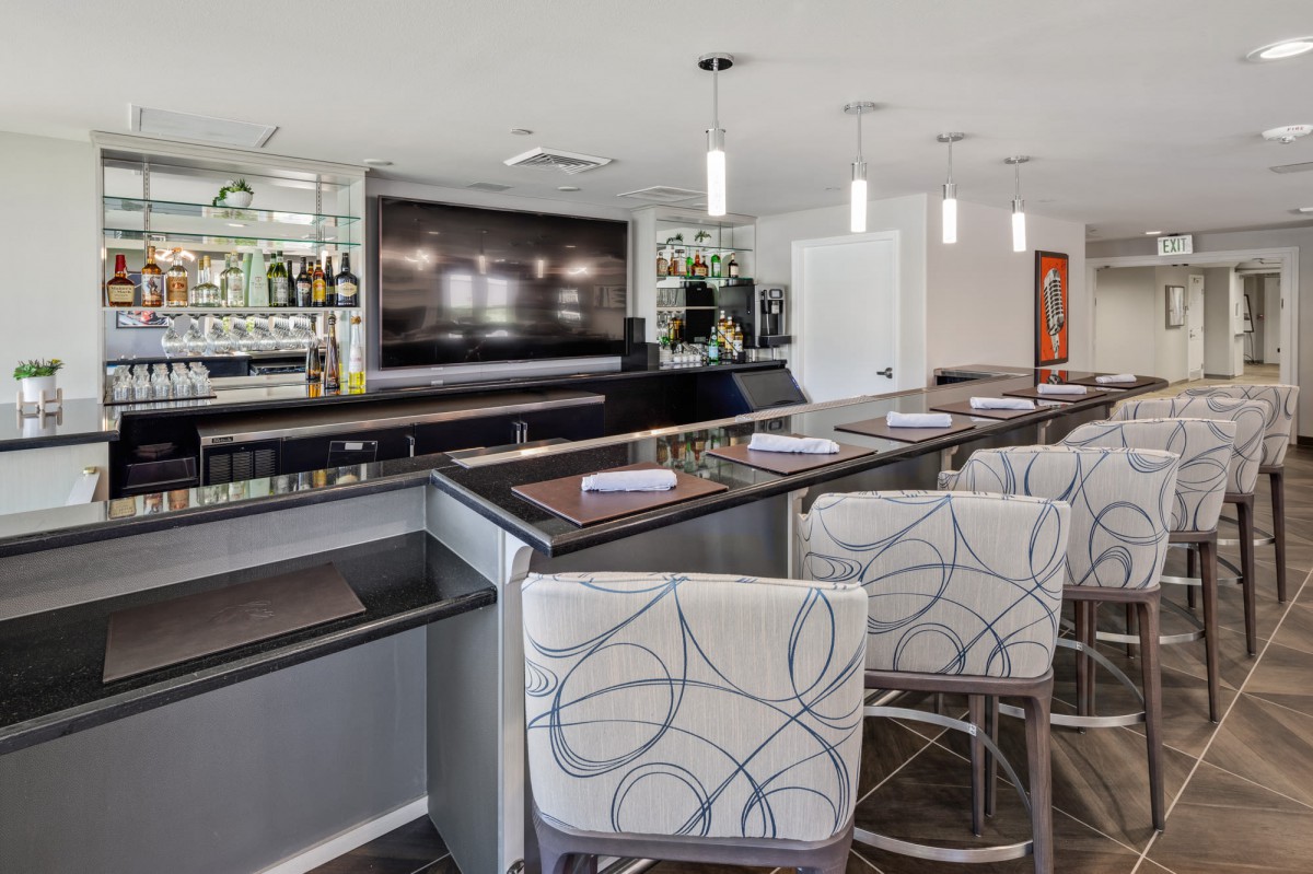 Modern bar interior with stylish seating and a well-stocked counter.
