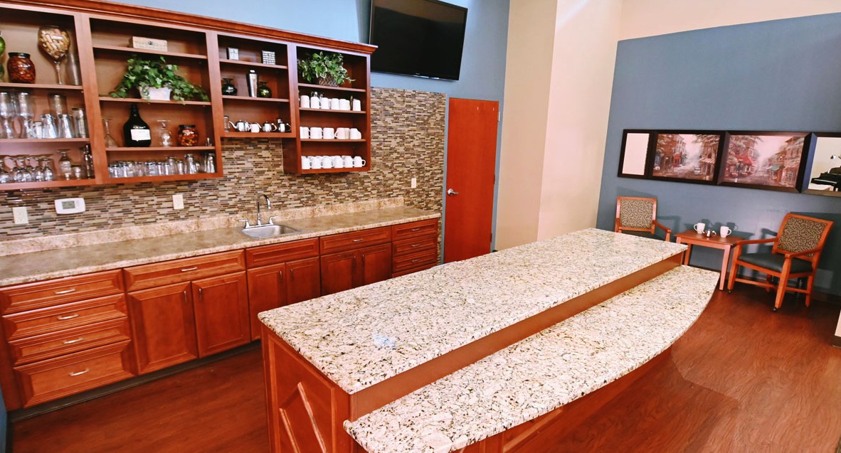 A modern kitchen with granite countertops and wooden cabinets.