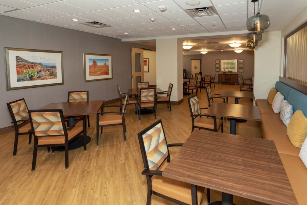 An empty dining room with wooden tables and chairs, featuring modern decor.