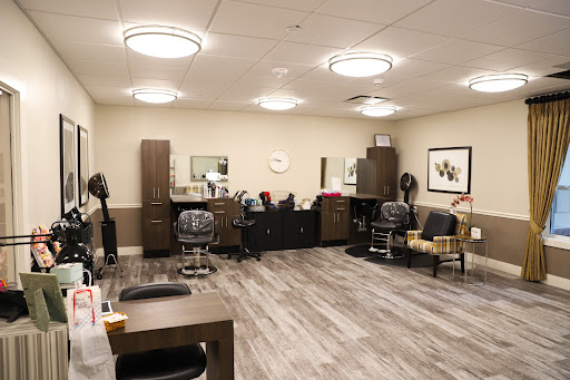 A well-designed interior of a modern hair salon, featuring comfortable seating and organized workstations.