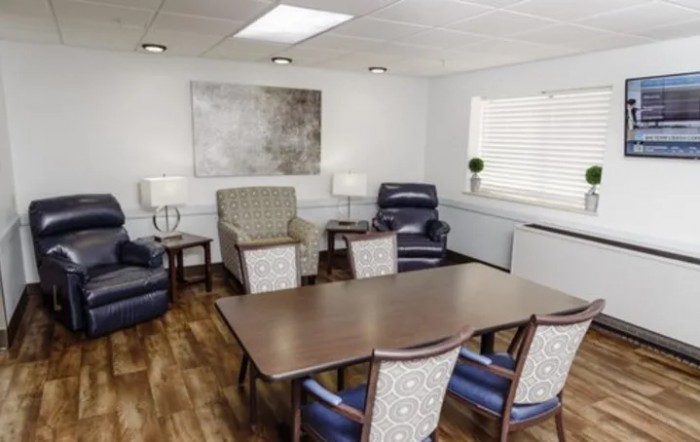 A cozy meeting room with a conference table, chairs, and comfortable armchairs.