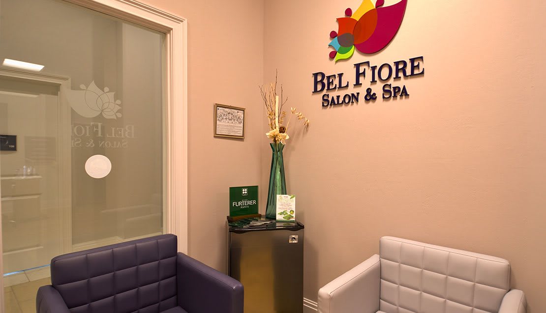 A cozy waiting area of a salon and spa with comfortable seating and elegant decor.