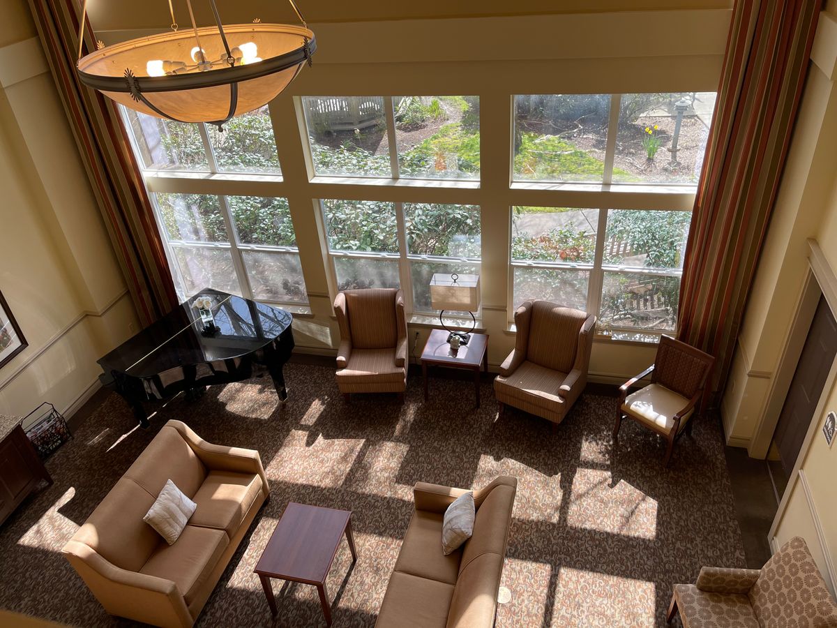 A cozy living room with ample seating and natural light streaming through large windows.