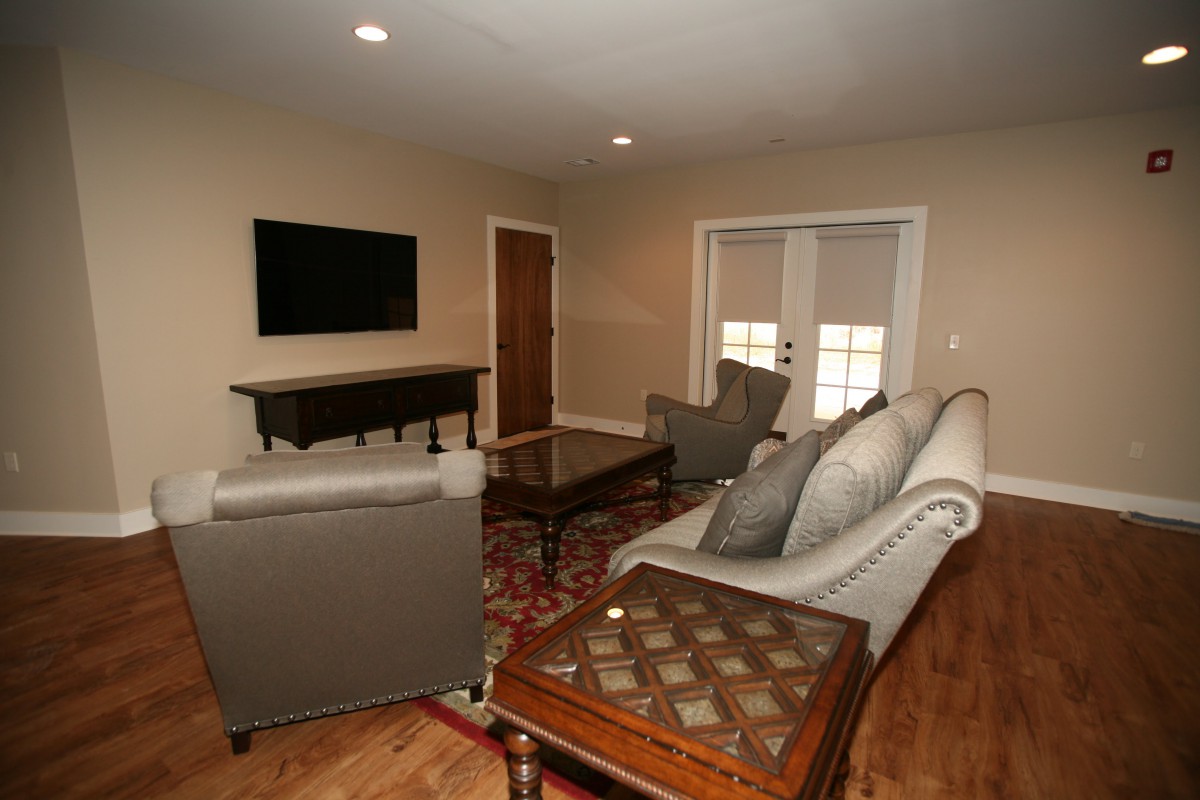 A cozy living room with modern furniture and a mounted television.