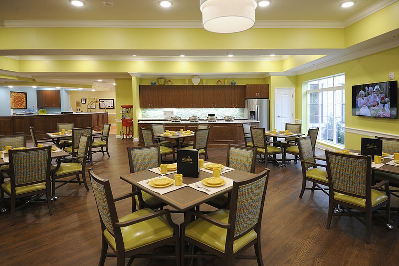 A modern dining area with neatly arranged tables and chairs, featuring bright lighting and contemporary decor.