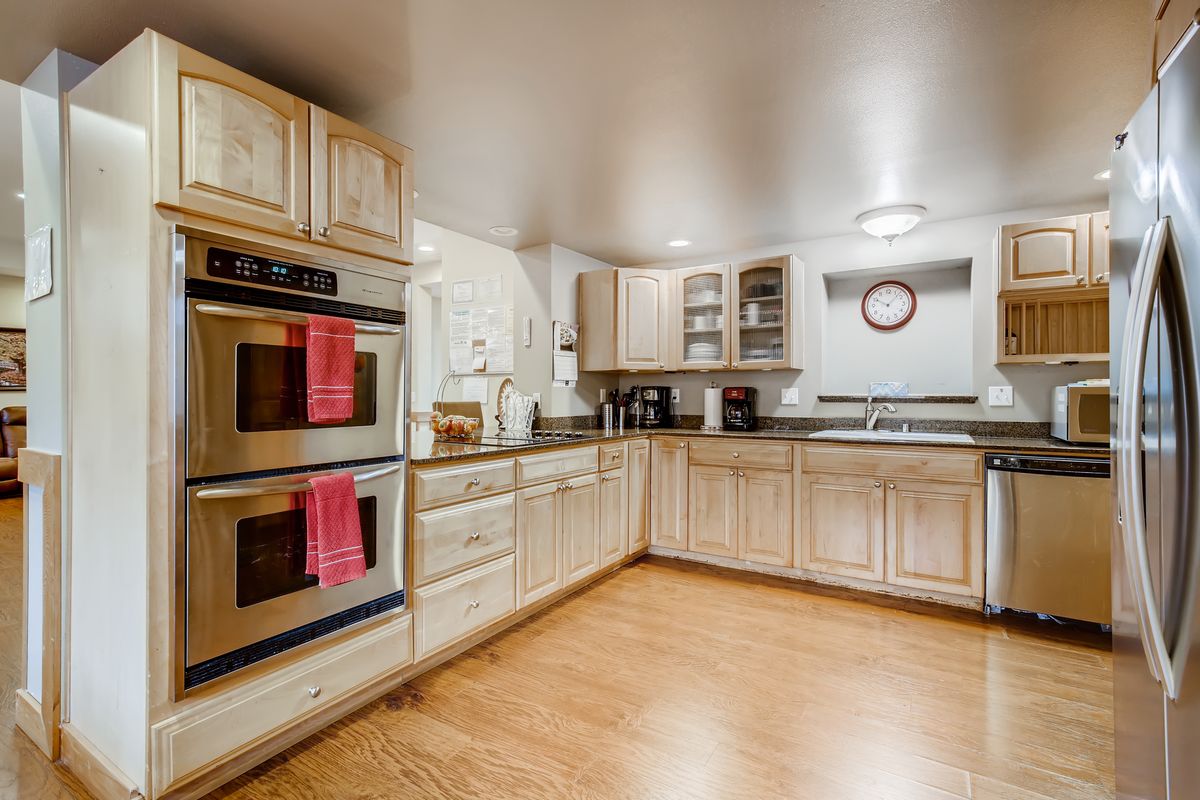 A modern kitchen with wooden cabinets and a double oven.