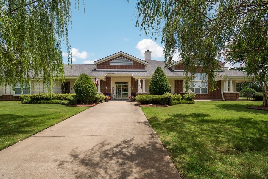 A suburban house with a well-maintained front yard and a long driveway.