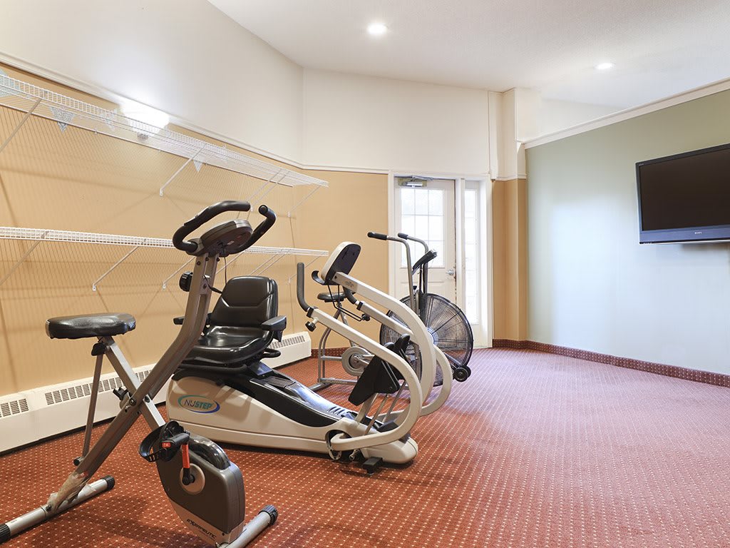 A small gym with various exercise equipment including stationary bikes.