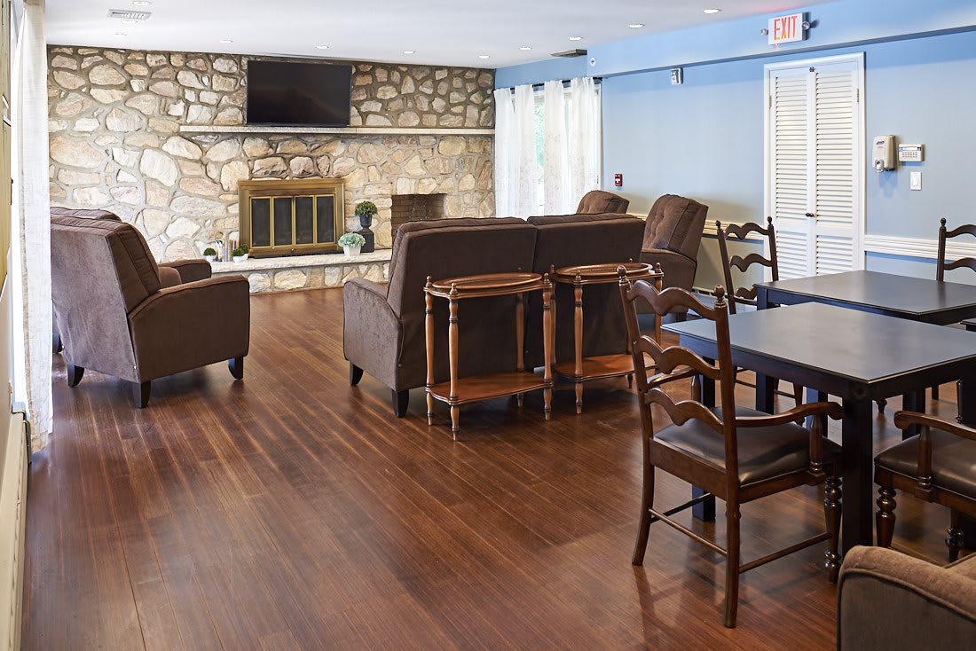 A cozy living room with a stone fireplace and wooden flooring.