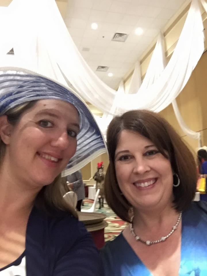 Two women smiling for a selfie indoors.