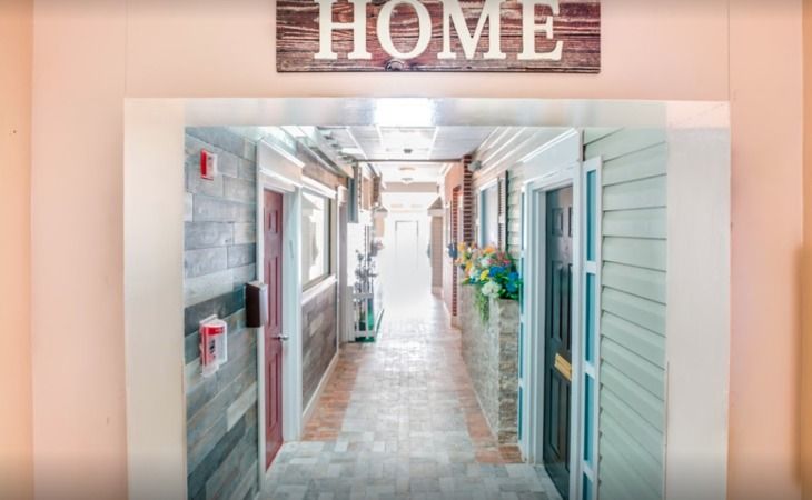 A cozy hallway with a wooden 'Home' sign and charming decor.