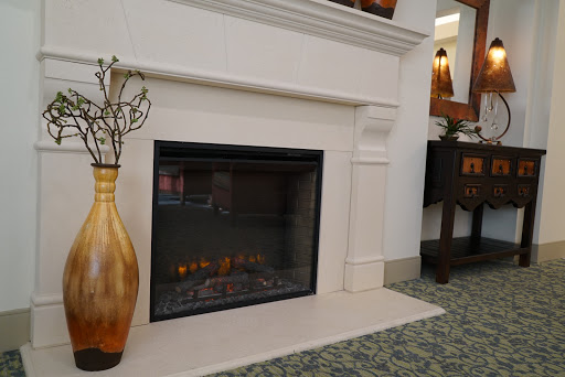 A stylish modern fireplace with a decorative vase beside it, set in a cozy interior.