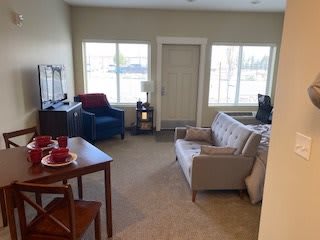 A cozy living room with a couch, chair, and television.