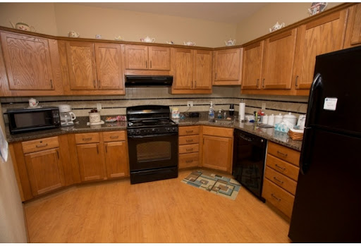 A cozy kitchen featuring wooden cabinets, granite countertops, and modern appliances.