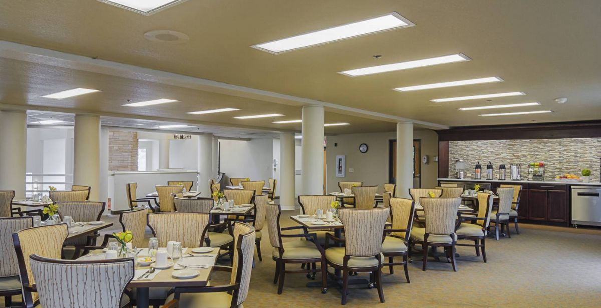 An empty dining room with neatly arranged tables and chairs.