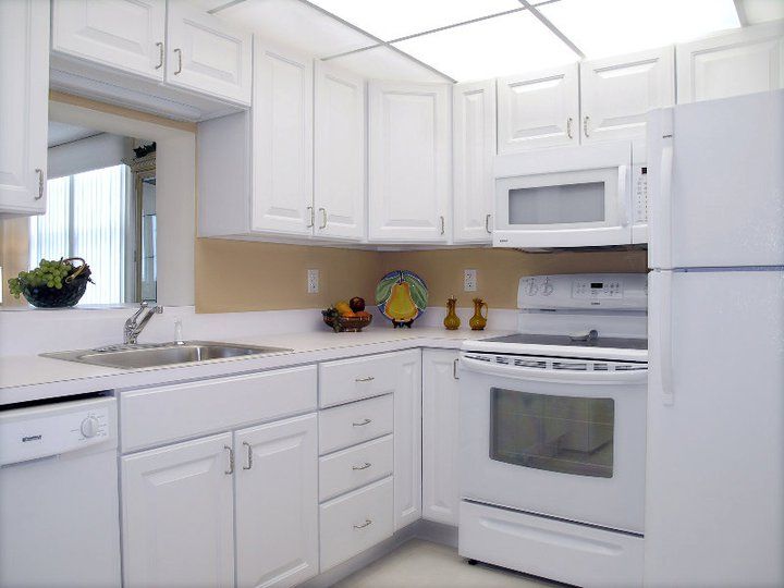 A modern kitchen with white cabinets and appliances.