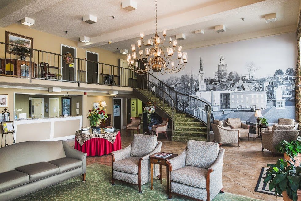 Elegant hotel lobby with a grand staircase and modern furnishings.