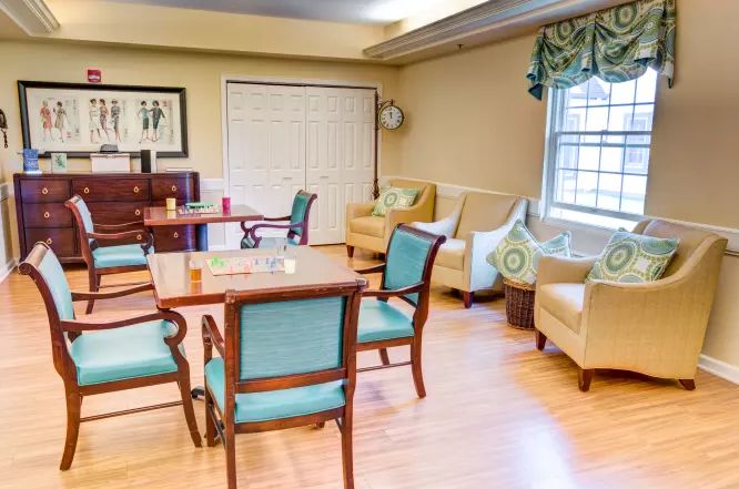 A cozy living room with comfortable seating and a table set on a wooden floor.