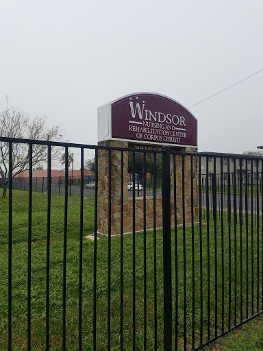 Entrance sign of Windsor facility surrounded by a fence on a cloudy day.