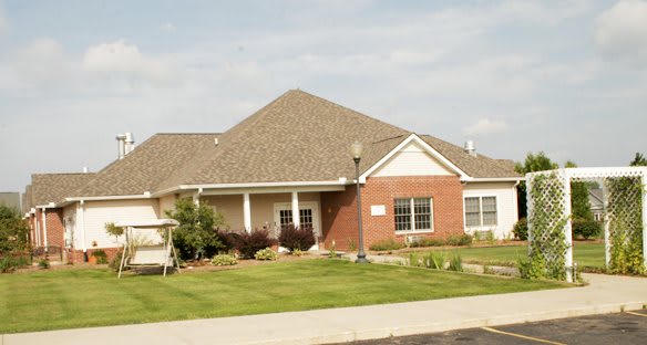 A suburban house with a well-maintained lawn and brick exterior.