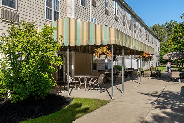 Outdoor patio area with seating and awning attached to a building.