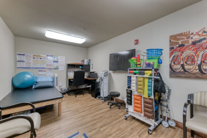A well-organized office with desks, storage shelves, and equipment.