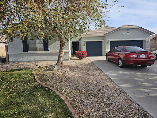 A charming residential house with a landscaped front yard and a parked car.
