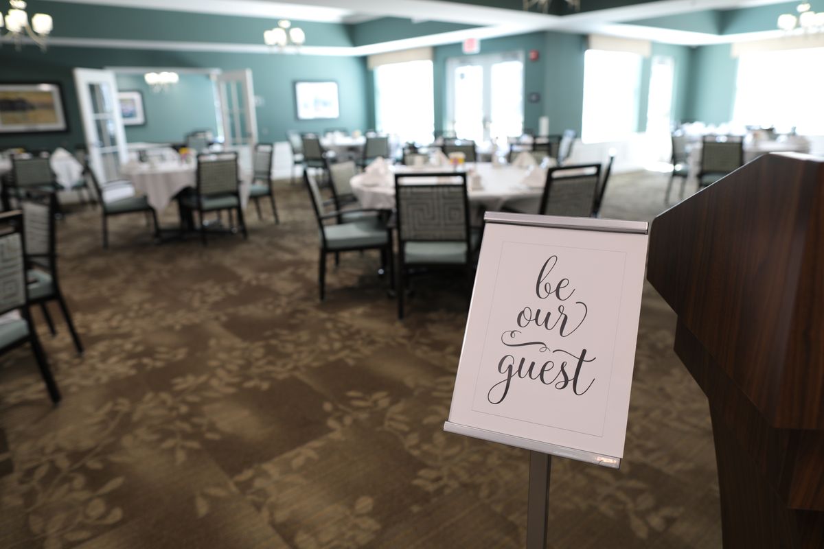 A dining area with neatly arranged tables and a welcoming sign that reads 'be our guest'.
