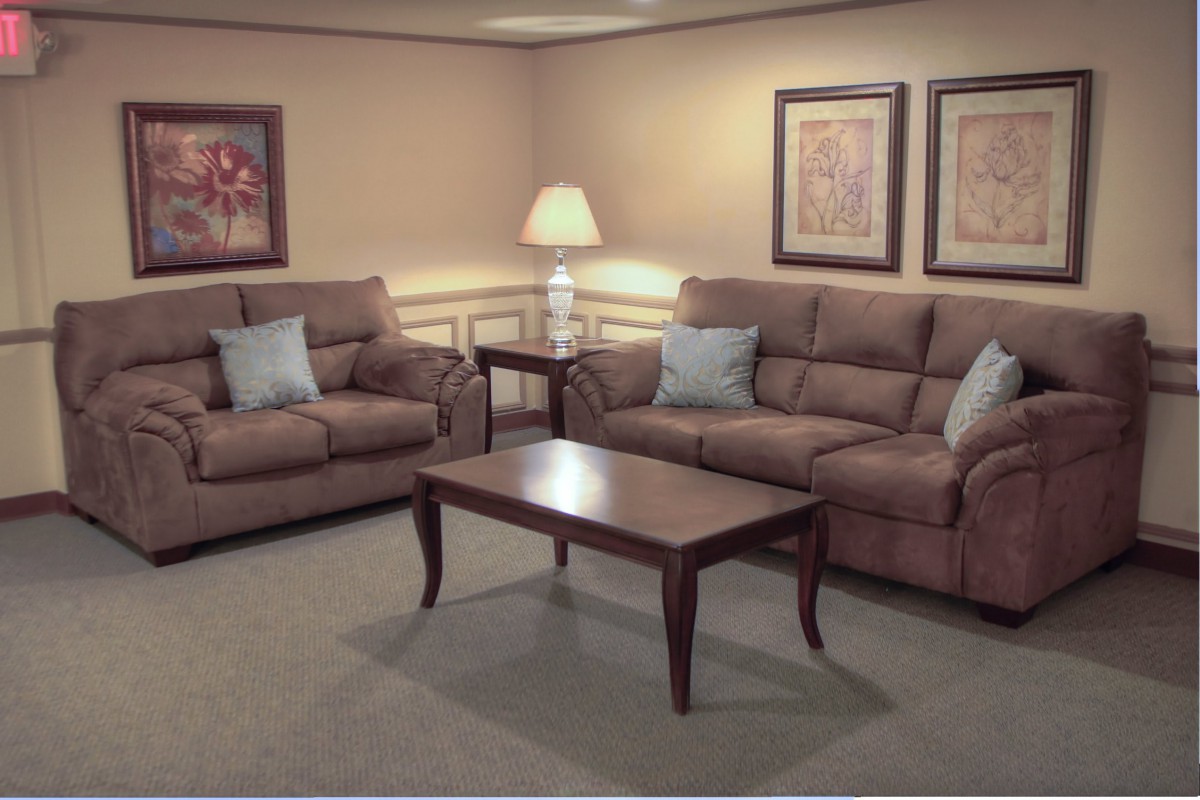 A cozy living room with comfortable sofas, a wooden coffee table, and warm lighting.