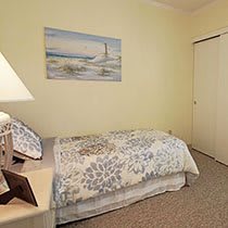 A cozy bedroom with a single bed and decorative wall art.