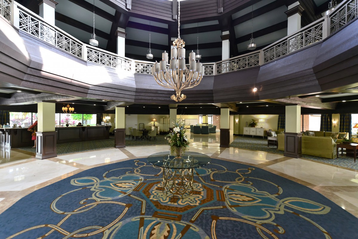 A luxurious hotel lobby featuring a grand chandelier and elegant decor.