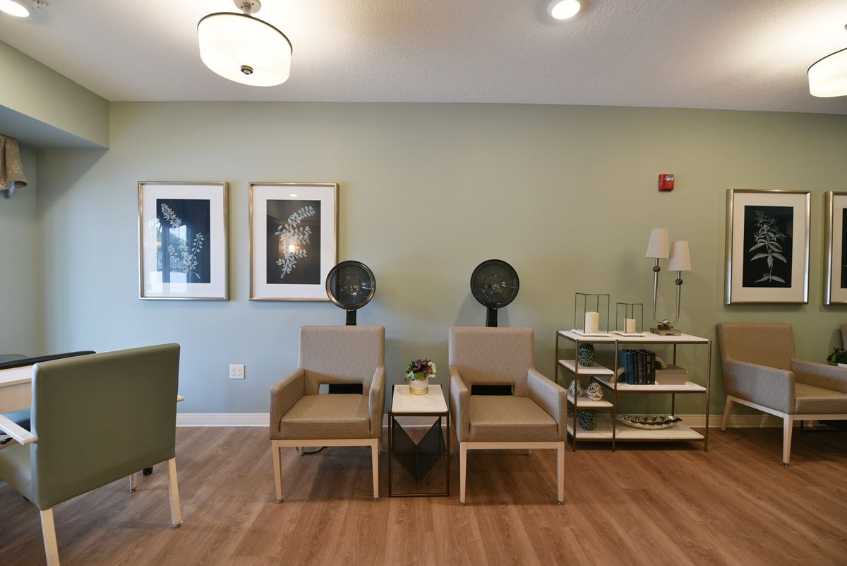 A modern waiting area with chairs, stylish decor, and green painted walls.