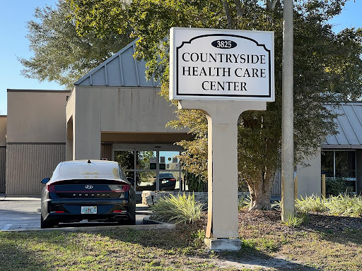 The entrance to Countryside Health Care Center, featuring a clear sign and parked vehicle.