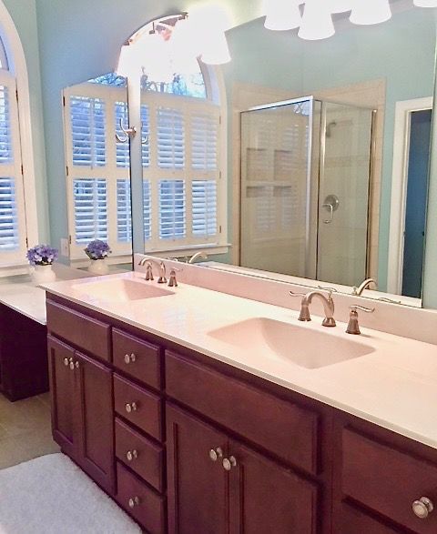 A well-lit bathroom with a double sink vanity and large mirrors.