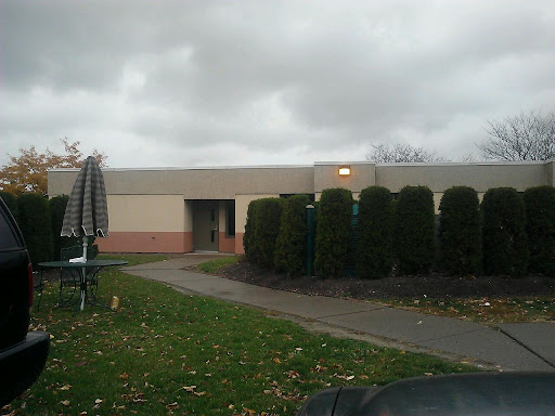 A quiet building surrounded by greenery on a cloudy day.