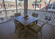 Outdoor patio with a table and four chairs on a balcony.