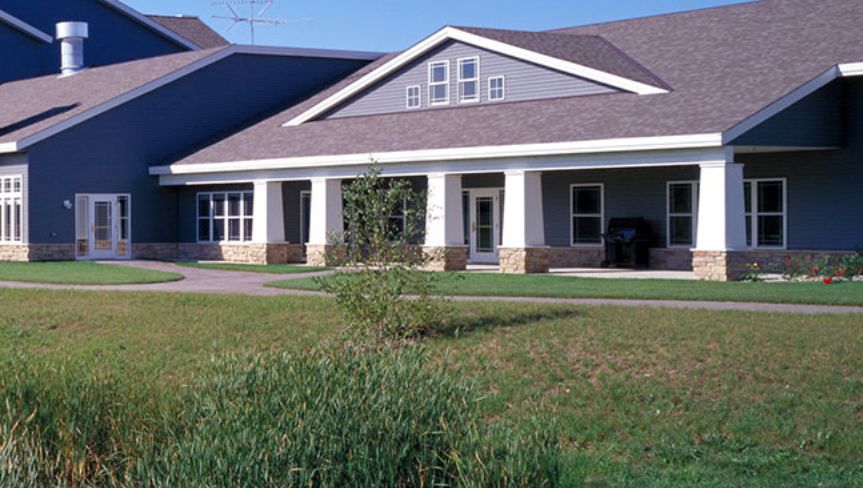A suburban residential house with a well-kept lawn and porch.