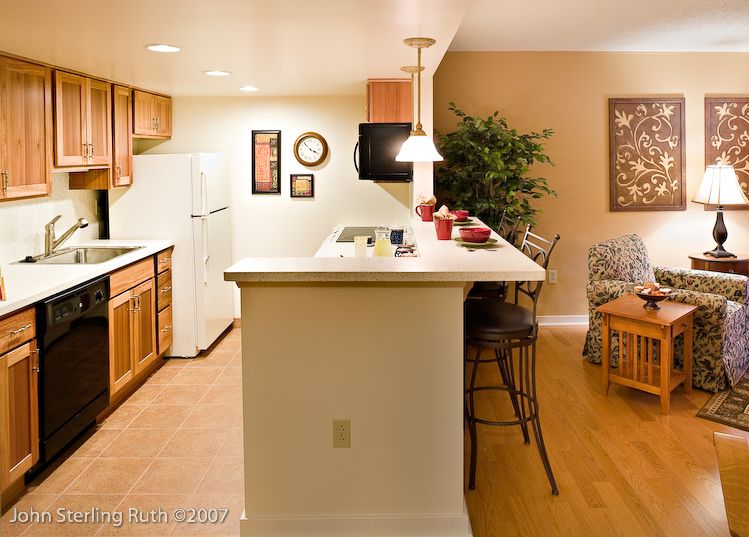 A cozy kitchen area with a breakfast bar, complete with bar stools and modern appliances.