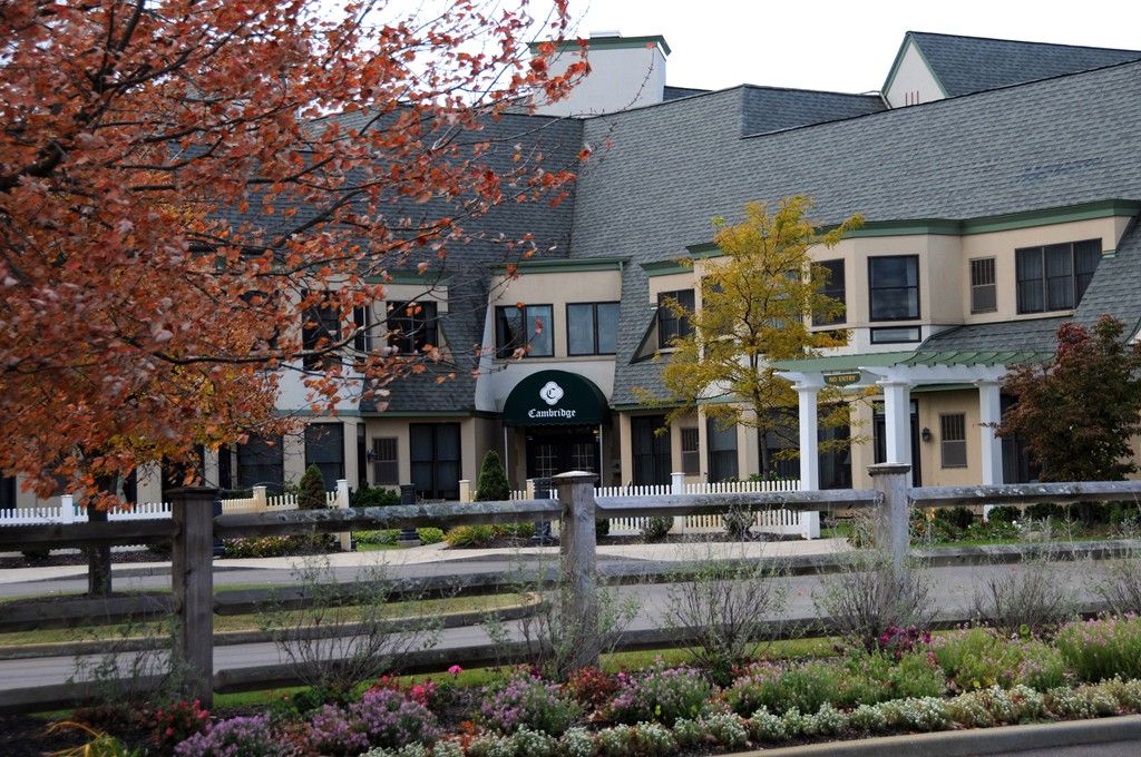 A charming building surrounded by autumn foliage and a wooden fence.