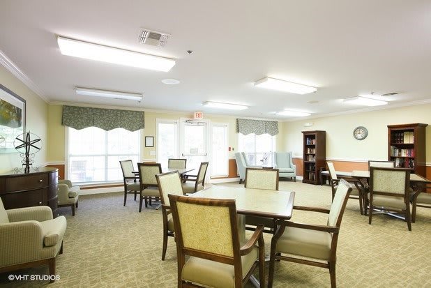 A well-lit dining area with several tables and chairs arranged for seating.