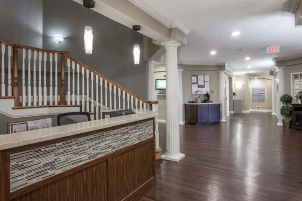 Modern reception area with a staircase and wood flooring.